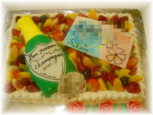【ドンペリでお誕生日のお祝いのケーキ】３０名様用のケーキに、ケーキで作ったドンペリとカードをのせて、フルーツいっぱい、ケーキの裾にバラのお花も飾りました。