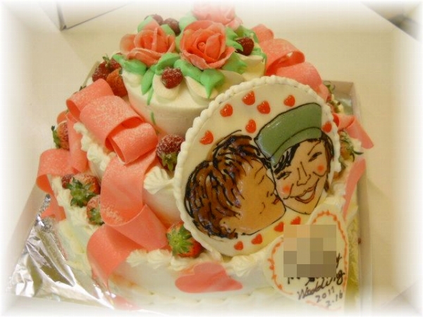 2011年4月のご注文です。3段の豪華なケーキにバラの花をトップに飾り、プレートに描いた似顔絵を飾りました。