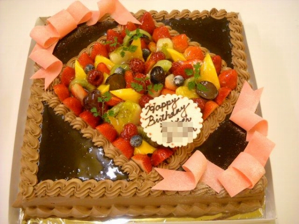 【チョコレートのケーキ】１０号サイズのチョコレートケーキに、フルーツと、チョコレートソース、リボンを飾りました。