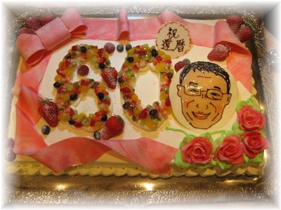 【還暦のお祝いに似顔絵のケーキ】３０ｃｍX４０cmのケーキに、すうじの「６０」をフルーツで真ん中に！バラの花と、似顔絵で、豪華なケーキになりました。