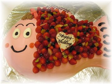 2009年4月のご注文です。作り続けてきた『おめで鯛』のケーキの、たいやき君風アレンジケーキです。丸粒苺をうろことして、顔もユニークに！おなかも、苺と生クリームがたっぷりです！デザイン画は、花嫁さんです。