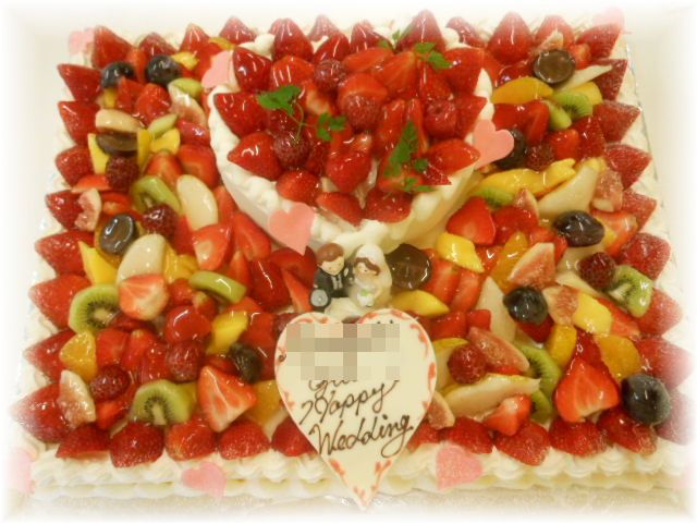 ２０１２年１０月のご注文です。　５０名様用のフルーツたっぷりのケーキに、６号サイズのハートのケーキを重ねた２段のケーキです。新郎新婦キャンドルを飾りました。